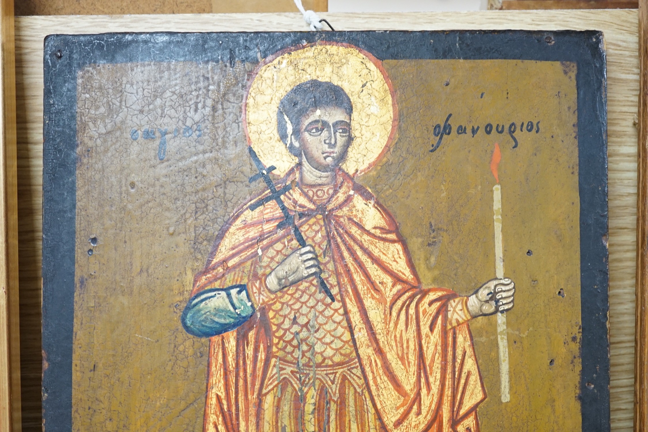 Greek School, tempera on wooden panel, Icon of a standing saint holding a candle, 33 x 24.5cm